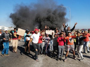 Photo of protest against background of burning barricade