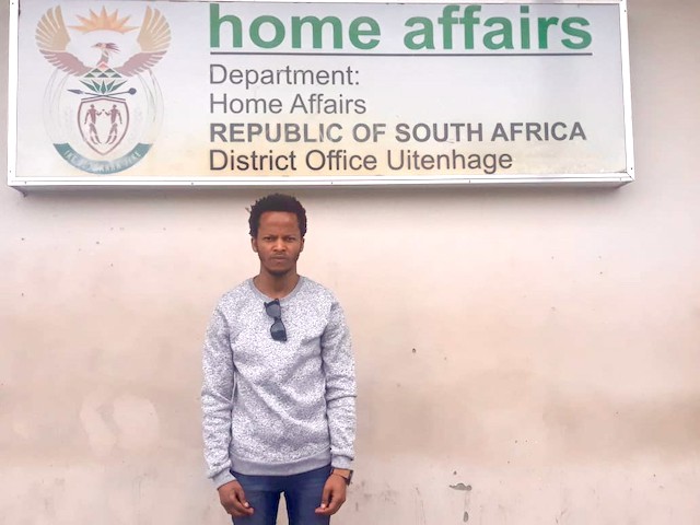 Photo of a man infront of a Home Affairs sign