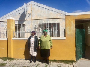 Photo of two people outside a house