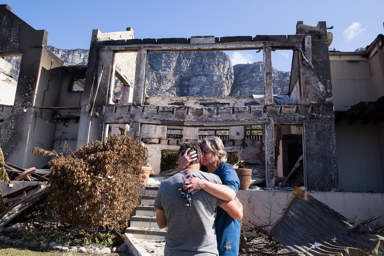 Juanita Booyse and her husband Manie break down in tears outside their destroyed home in Bettysbay. The Booyses have been staying in Bettysbay for 9 years years and the lost of their home is “tragic”.