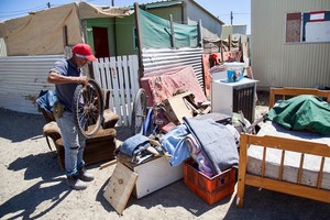Photo of a man and belongings in the street outside a house