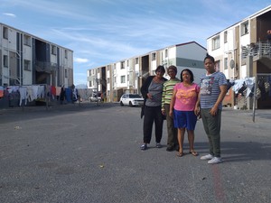 Photo of four people against background of flats