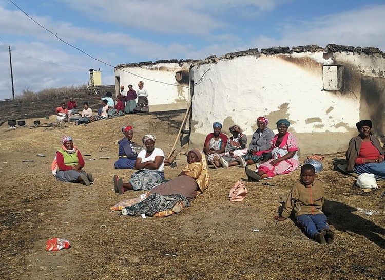 Photo of villagers sitting on the ground