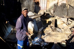Photo of a man and a burnt out shack