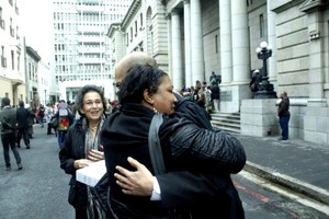 Photo of two people embracing outside a court building