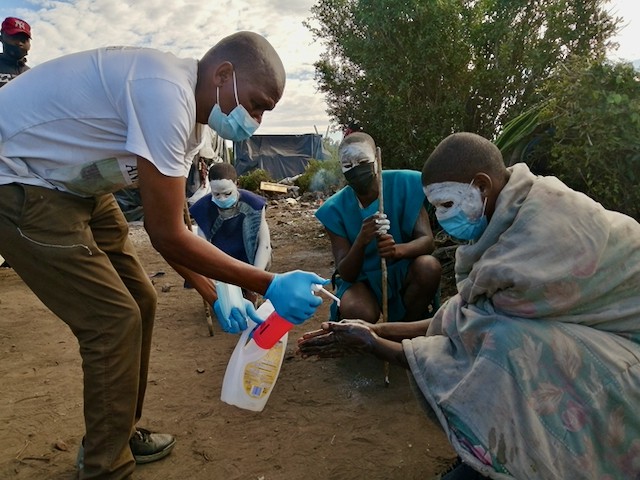 Photo of a man washing initiates hands