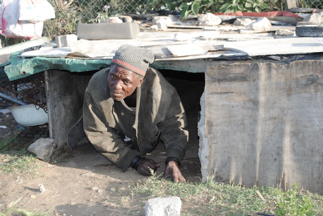 Photo of a man climbing out of a hovel