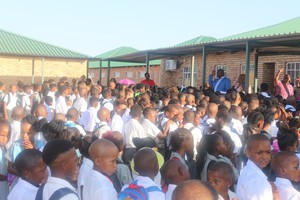 Photo of man addressing crowd of children at school