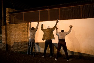 Photo of three men against a wall