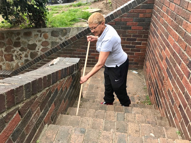 Photo of a woman sweeping stairs