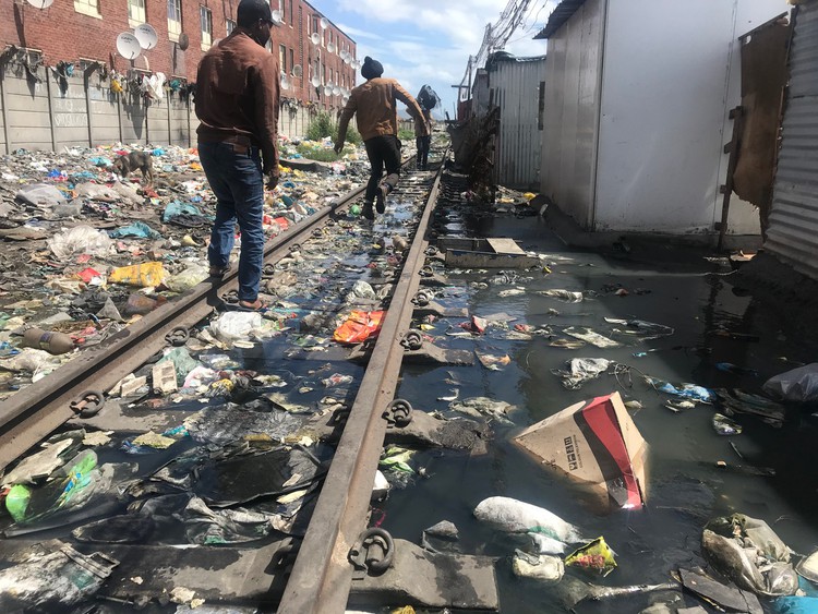 Photo of people and rubbish strewn railway tracks