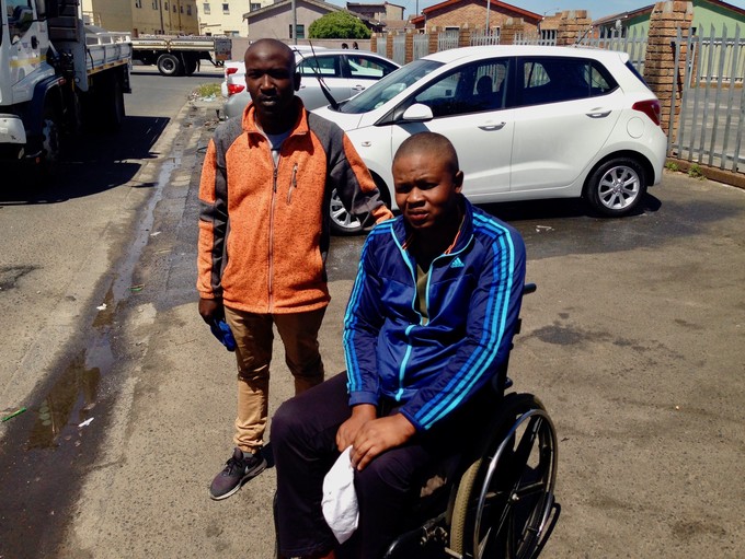 Photo of two men, one in a wheelchair