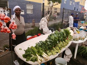 Photo of a woman at her vegetable stand