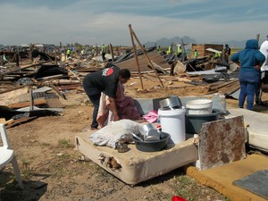 Photo of a woman and a demolished shack