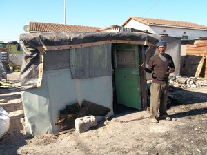 Photo of fire victim in front of his new shack