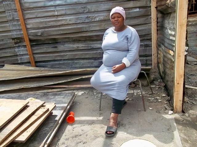 Photo of a woman outside a shack