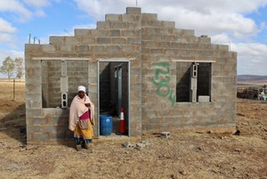 Photo of a woman in front of a half built house