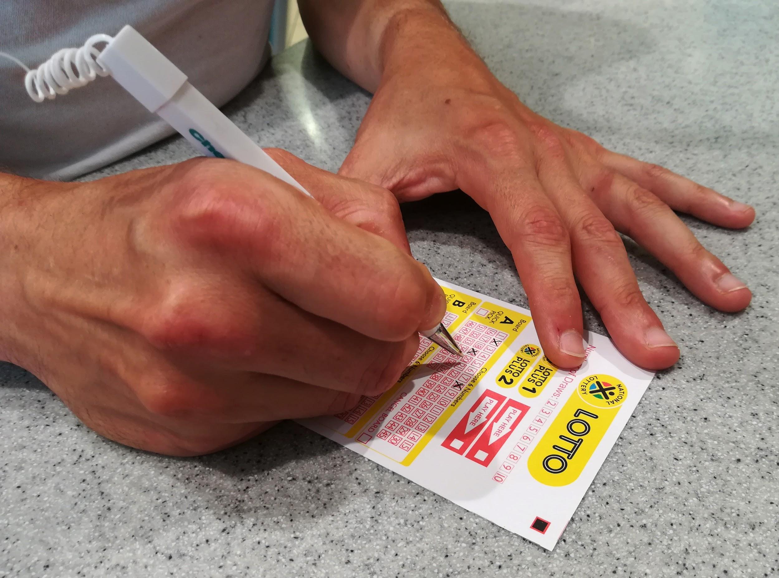 Photo of hand filling in Lottery ticket